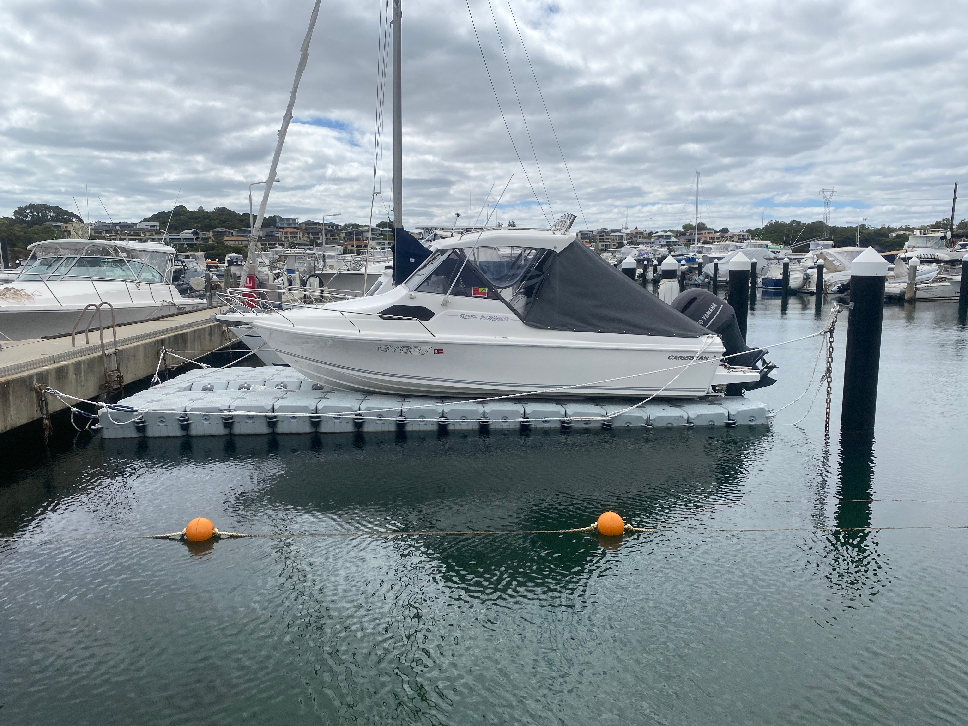 FloatX modular floating dock, boat hull elevated out of the water at WA marina